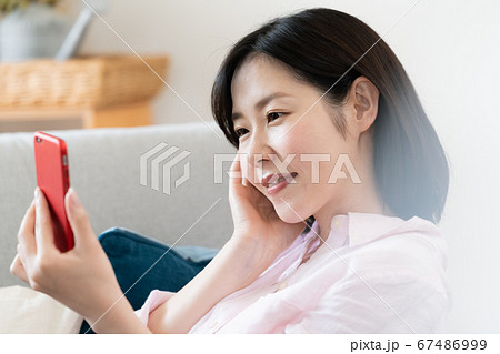 リビングでスマホを見るミドル女性 リビングでスマホを見るミドル女性 67486999