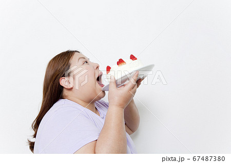 ケーキを食べるメタボ女性 67487380