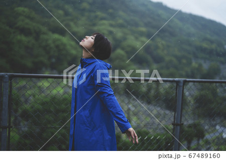 雨の中でレインコートを着た女性 雨の中でレインコートを着た女性 67489160