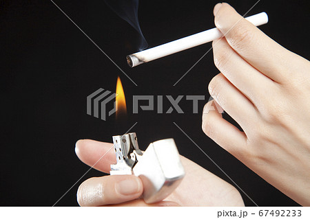 タバコに火を点ける手の写真素材