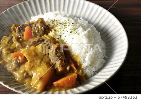 熱々で湯気が上がるジャガイモ、人参、牛すじ肉がたくさん入ったカレーライス 67493363