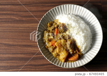 熱々で湯気が上がるジャガイモ、人参、牛すじ肉がたくさん入ったカレーライスを俯瞰で撮影 67493405