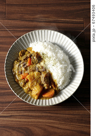 熱々で湯気が上がるジャガイモ、人参、牛すじ肉がたくさん入ったカレーライスを俯瞰で撮影 67493406