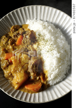 熱々で湯気が上がるジャガイモ、人参、牛すじ肉がたくさん入ったカレーライス(黒背景) 熱々で湯気が上がるジャガイモ、人参、牛すじ肉がたくさん入ったカレーライス(黒背景) 67493507