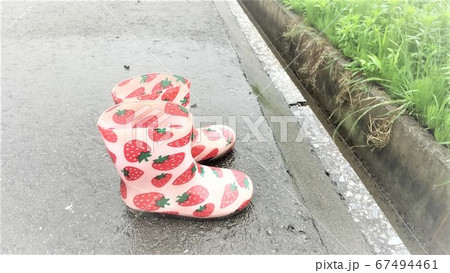 雨の日に置き去りにされたいちごの模様の長くつをアップに。子供の頃の寂しさ感がある画像です。 雨の日に置き去りにされたいちごの模様の長くつをアップに。子供の頃の寂しさ感がある画像です。 67494461