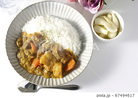 ジャガイモやニンジンがたくさん入った熱々の牛すじカレーとお冷やらっきょう、そして薔薇の造花 ジャガイモやニンジンがたくさん入った熱々の牛すじカレーとお冷やらっきょう、そして薔薇の造花 67494617