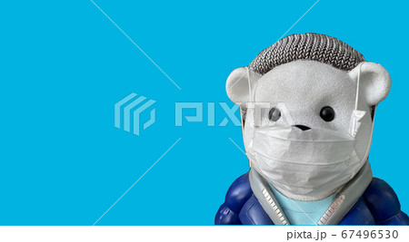 Teddy bear isolated wearing medical protective mask blue background 67496530