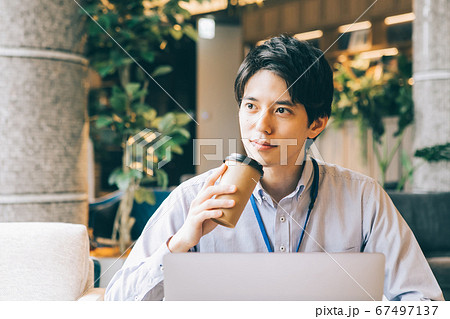 コーヒーを飲みながら仕事をする男性 の写真素材