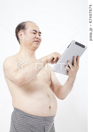 タブレットPCを見るメタボ男性 67497674
