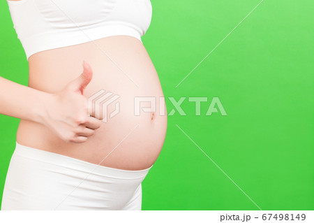Cropped shot of positive pregnant woman in white Cropped shot of positive pregnant woman in white 67498149