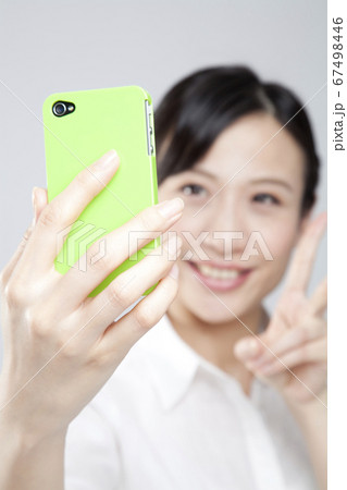 携帯電話で自撮りする女性 67498446