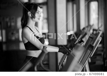 Fit brunette girl training in gym. 67499081