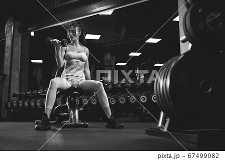 Fitnesswoman training with dumbbells, monochrome. 67499082