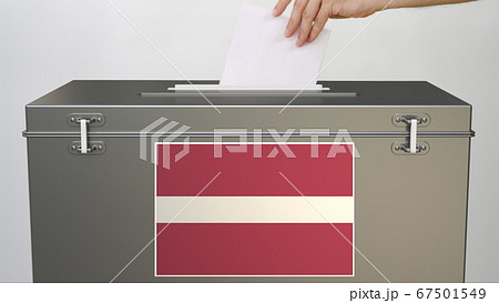 Hand putting paper ballot into ballot box with flag of Latvia. Election related 3d rendering Hand putting paper ballot into ballot box with flag of Latvia. Election related 3d rendering 67501549