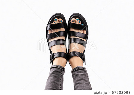Womans feet with pedicure in black trendy sandals on gray background 67502093
