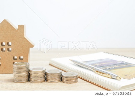 House model and notepad with coins on table House model and notepad with coins on table 67503032