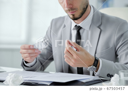 Taking pill at workplace 67503457