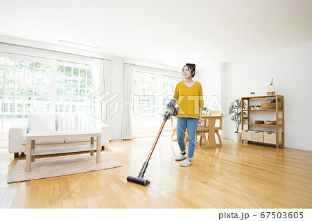 リビングルームを掃除する若い女性 67503605