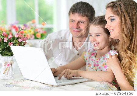 Girl with mother and father drawing at home 67504356