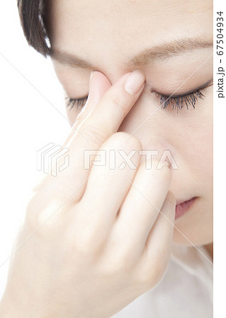 目頭を押さえる女性 67504934