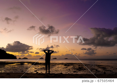 Silhouette of a man on the beach at sunset. Man 67505464