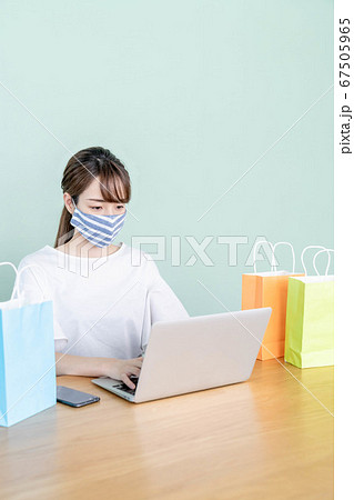 パソコンでオンラインショッピングをする若い女性 【マスク着用】 パソコンでオンラインショッピングをする若い女性 【マスク着用】 67505965