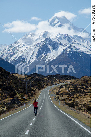 Girl running on the road to the Mount Cook, South Island, New Zealand, Mount Cook National Park 67509289