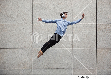 Jumping young buinessman in front of buildings, on the run in jump high Jumping young buinessman in front of buildings, on the run in jump high 67509968