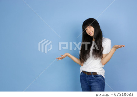 Portrait of young asian woman isolated on blue studio background 67510033