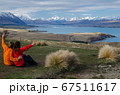 Two people sitting and looking at Lake tekapo from Mount John observatory, South Island, New Zealand 67511617