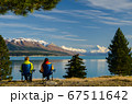 Two people sitting on camping chairs looking at distant Mount Cook across Lake Pukaki, South Island, New Zealand 67511642