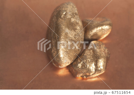 Golden nuggets on a copper background Golden nuggets on a copper background 67511654