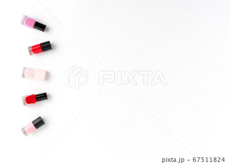 Red and pink nail polishes on white background with copyspace. Top view 67511824
