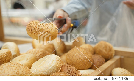 Woman selecting rolls in a bakery Woman selecting rolls in a bakery 67511862