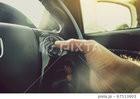 Driver hand pressing to adaptive cruise control button Driver hand pressing to adaptive cruise control button 67513603