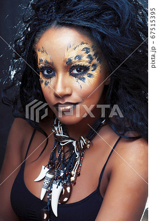 beauty afro girl with cat make up, creative leopard print on face closeup halloween woman 67515395