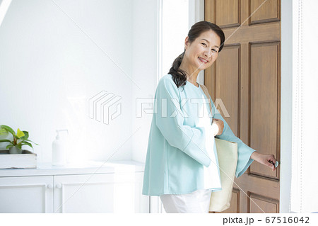 玄関扉を開ける女性 67516042
