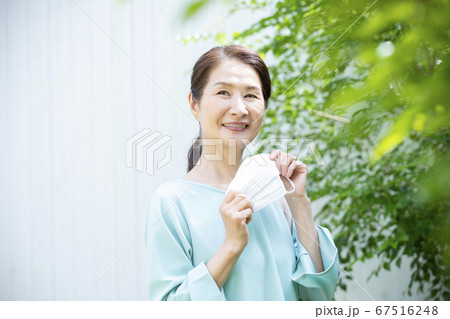 マスクを持って外出する女性 67516248