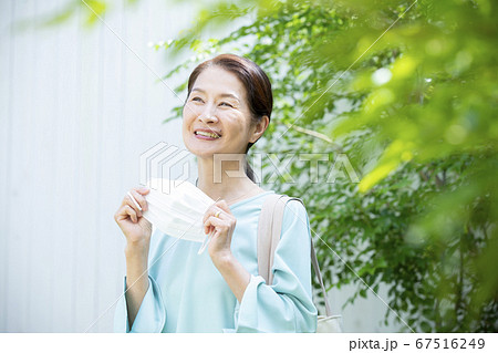 マスクを持って外出する女性 67516249