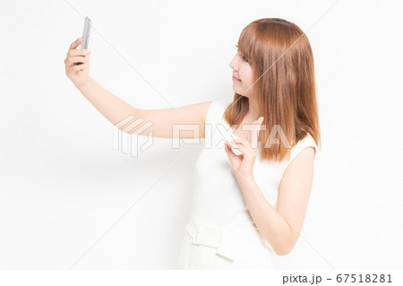 スマホで自撮りするワンピースを着た女性 スマホで自撮りするワンピースを着た女性 67518281