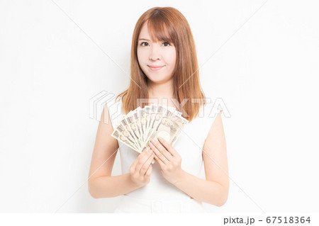 お金を手に持つワンピースを着た女性 67518364