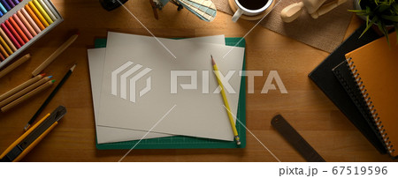 Wooden worktable with sketch paper, painting 67519596