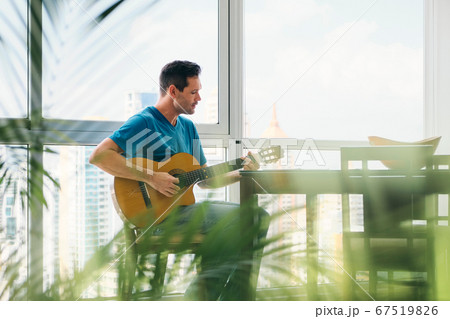 Portrait Of Man Playing Classic Guitar And Singing At Home Portrait Of Man Playing Classic Guitar And Singing At Home 67519826