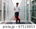 Handsome asian boy checking his smartphone in the hallway.  67519853