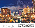 夜の川に浮かぶ船を囲むビル 67520253