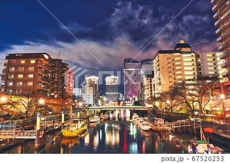 夜の川に浮かぶ船を囲むビル 夜の川に浮かぶ船を囲むビル 67520253
