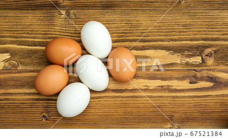 Chicken egg and duck egg on a wooden table. Chicken egg and duck egg on a wooden table. 67521384
