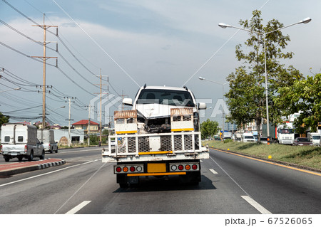 Rear of tow truck loading broken car of crash Rear of tow truck loading broken car of crash 67526065
