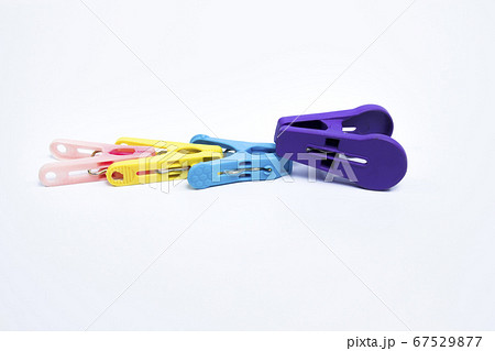 4 plastic clothes pins arranged in violet, yellow, blue, pink 67529877