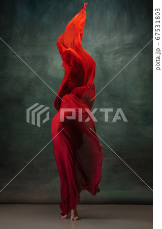 Young graceful tender ballerina on dark green studio background 67531803